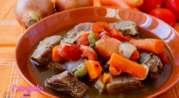 Un invitante brodo di carne con pezzi succulenti, carote, pomodori e cipolle. Un piatto caldo e confortante, perfetto per le giornate fredde.
