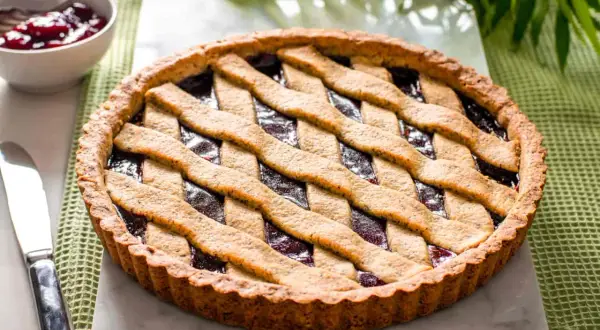 Deliziosa crostata grano saraceno con ripieno di marmellata scura, decorata con una griglia di pasta.