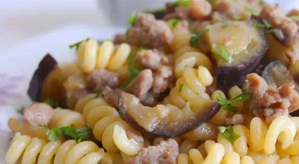 Fusilli con salsiccia e melanzane, un piatto gustoso e colorato, pronto per essere assaporato.