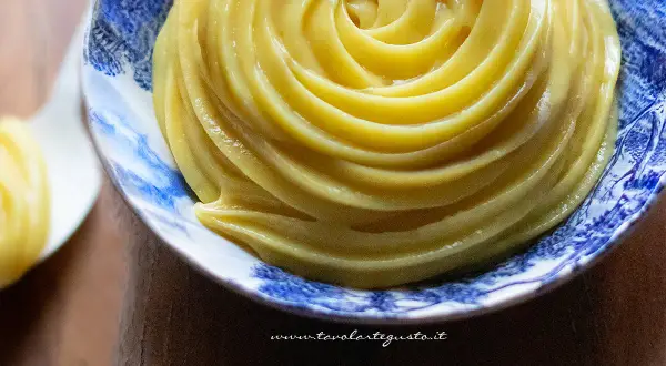 Una spirale perfetta di crema al latte, liscia e invitante, in una ciotola decorata.