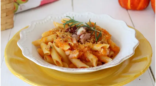 Penne con crema di zucca, pancetta croccante e rosmarino. Un piatto autunnale che celebra i sapori della terra.