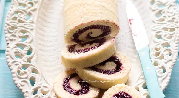 Un invitante rotolo alla marmellata, con la sua soffice pasta e il ripieno colorato, pronto per essere gustato.