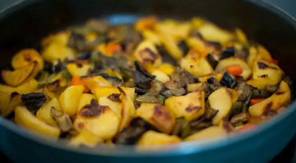 Un saporito contorno di melanzane e patate al forno, dorate e pronte per essere gustate.