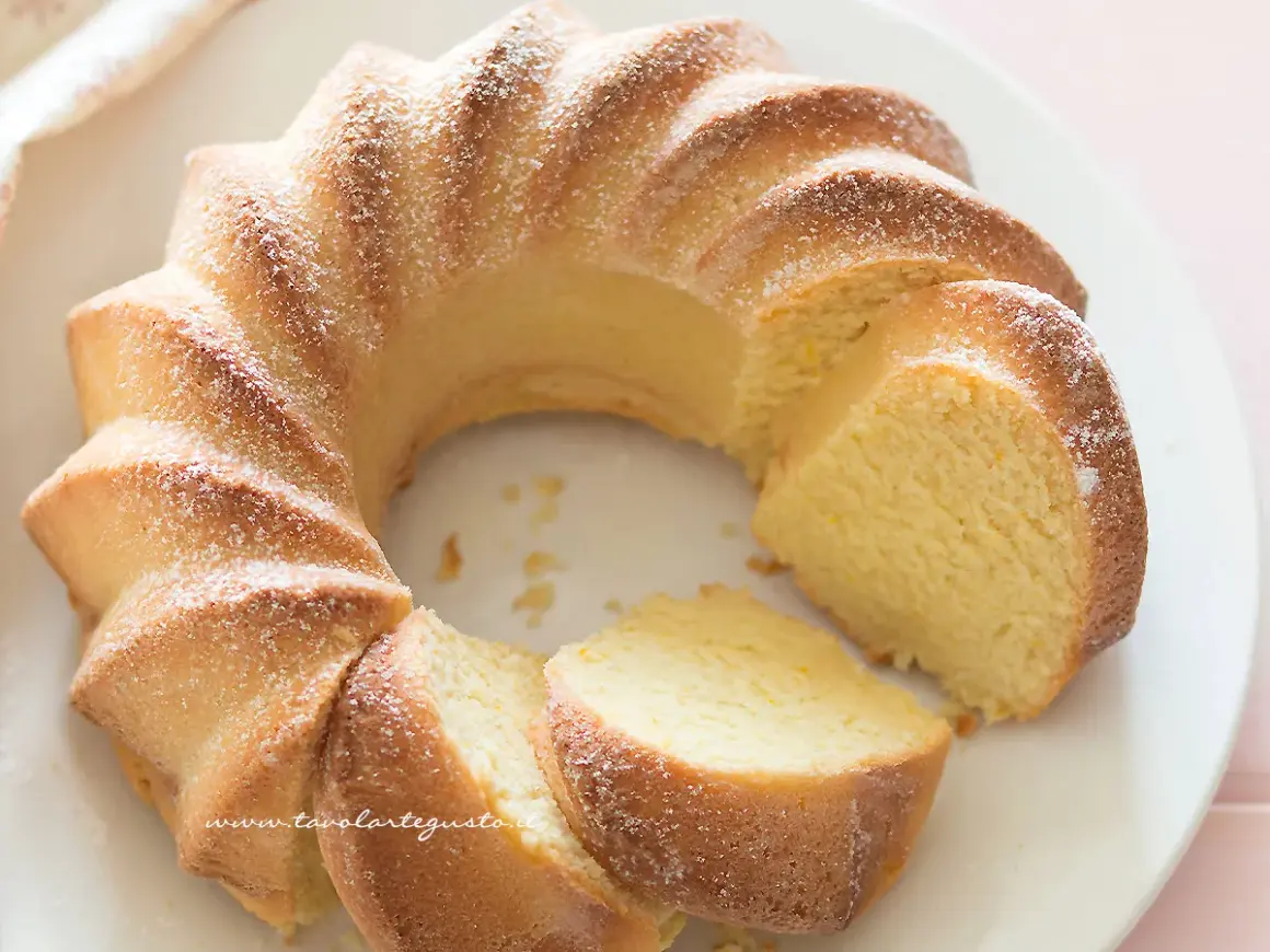 Deliziosa torta di ricotta, soffice e profumata, spolverata di zucchero a velo su un piatto bianco.