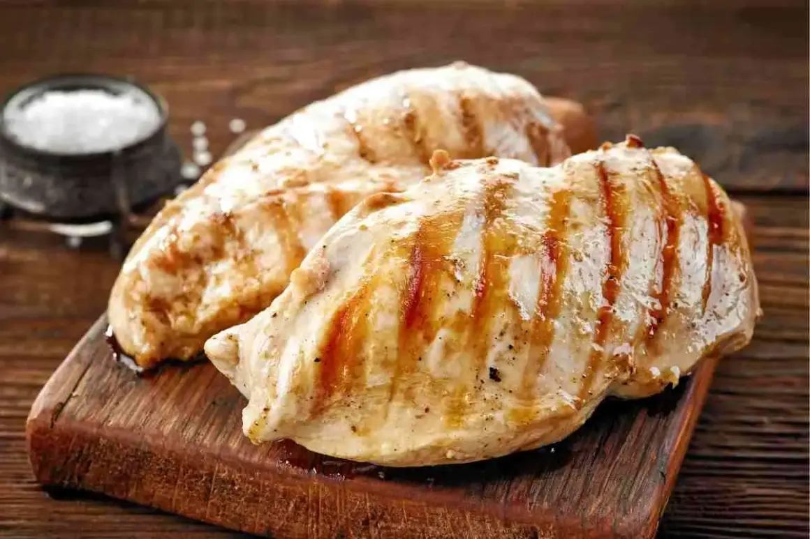 Petto di pollo grigliato, perfetti secondi di carne da preparare in anticipo. Un contorno di sale completa l'immagine.