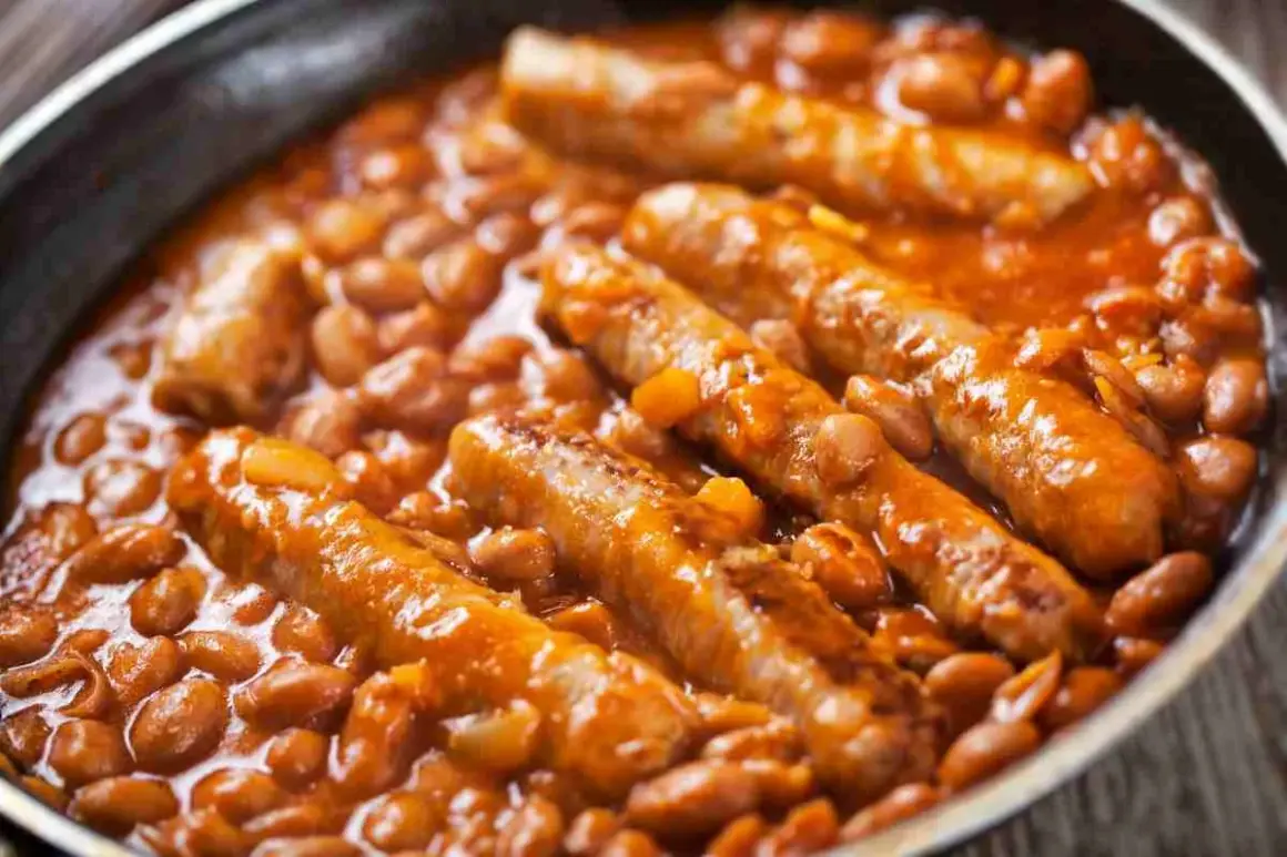 Salsiccia e fagioli in padella, un piatto confortante e saporito, con le salsicce dorate immerse in un letto di fagioli rossi in salsa.