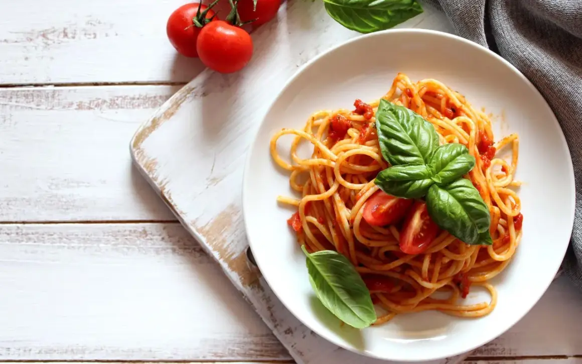 Spaghetti conditi con sugo di pomodoro fresco e basilico, guarniti con pomodorini. Un piatto semplice e gustoso.