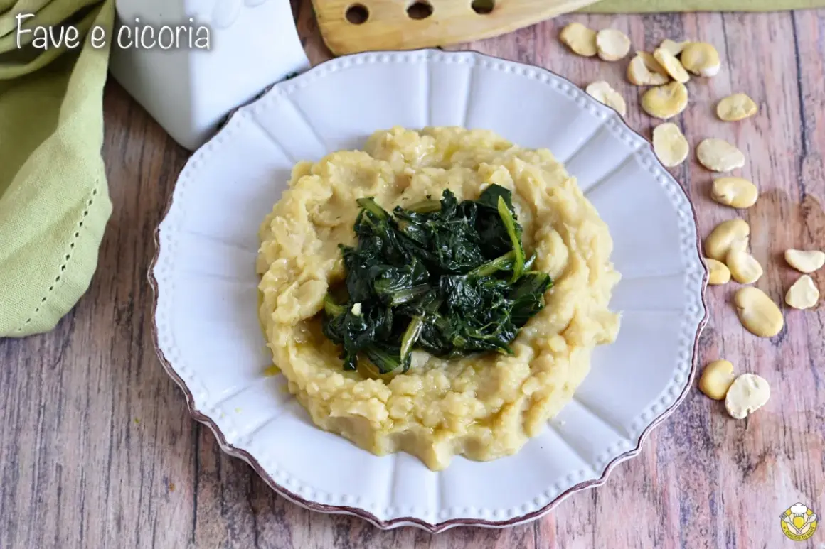 Piatto di fave e cicoria, un classico della cucina pugliese, servito su un piatto bianco con fave secche sparse attorno.