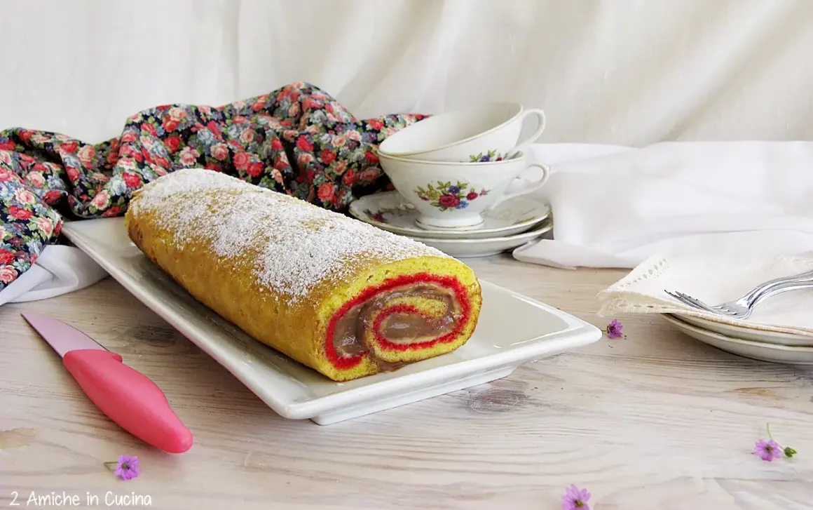 Rotolo dolce spolverato di zucchero a velo, un vero salame del re, con ripieno cremoso e bordi rossi.