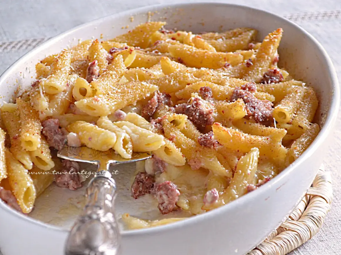 Un invitante piatto di pasta al forno con salsiccia, gratinata e dorata, pronta per essere gustata.