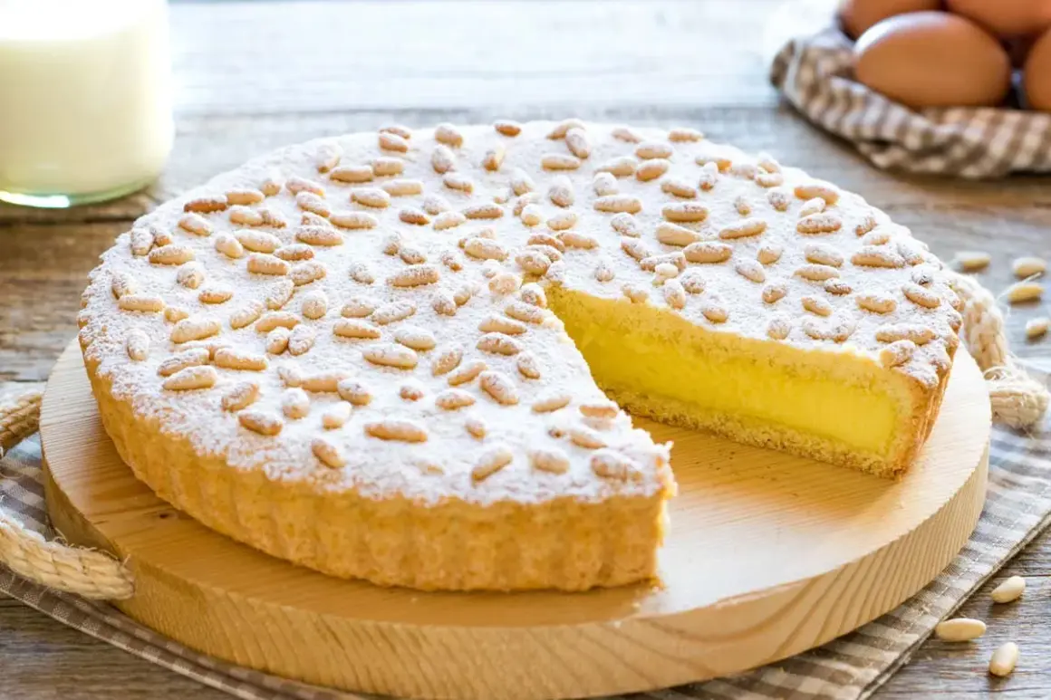 Una deliziosa torta della nonna, con crema gialla e pinoli tostati, spolverata di zucchero a velo.