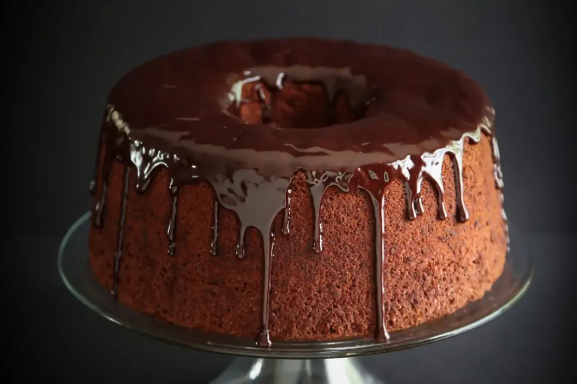 Delizioso chiffon cake al cioccolato con glassa lucida che cola.