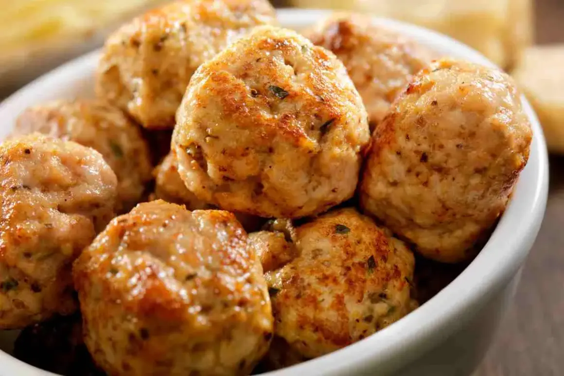 Un primo piano di polpette di tacchino dorate e saporite in una ciotola bianca, pronte per essere gustate.