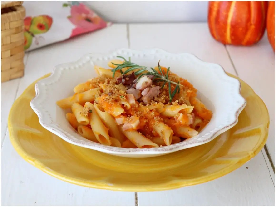 Penne con crema di zucca, pancetta croccante e rosmarino. Un piatto autunnale che celebra i sapori della terra.