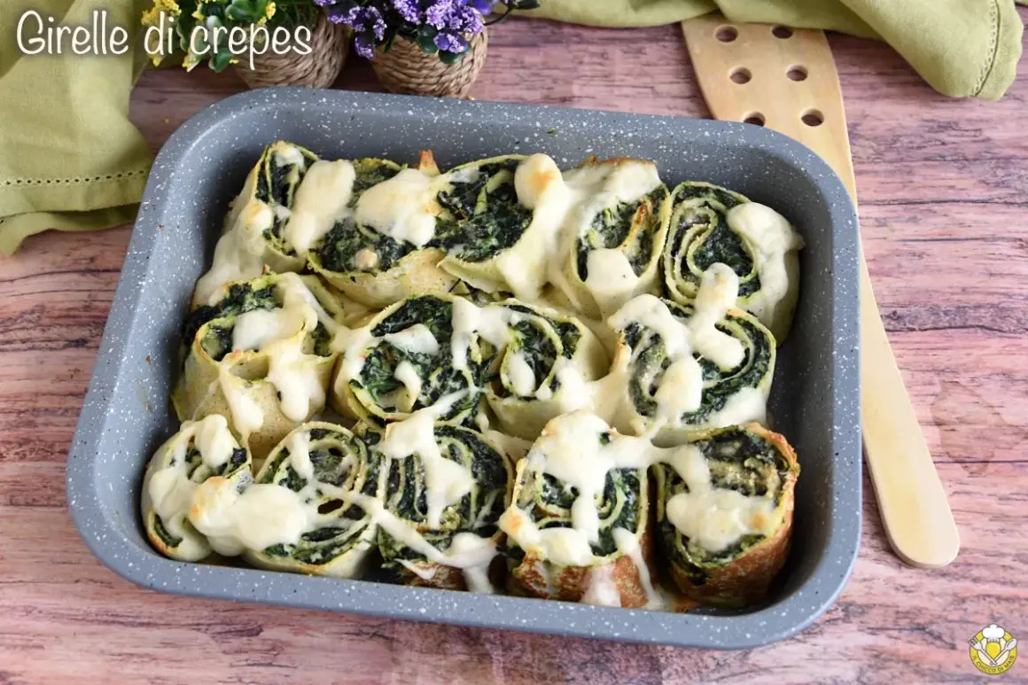 Girelle di crepes con spinaci e formaggio filante, un piatto invitante e gustoso.