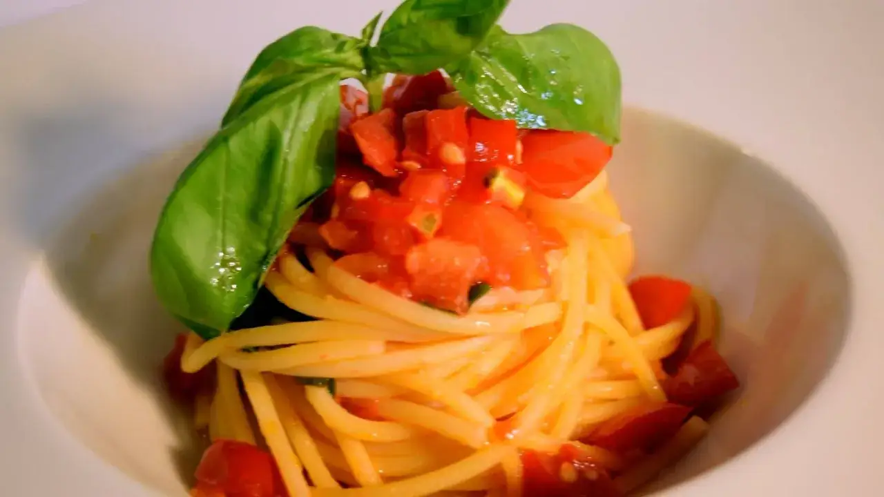 Spaghetti conditi con un delizioso sugo di pomodoro fresco e basilico, un classico intramontabile.