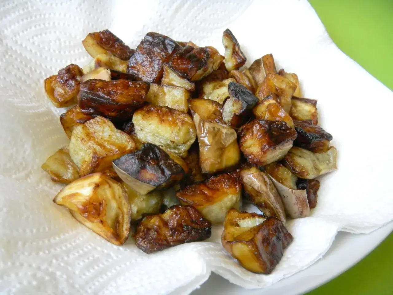 Melanzane fritte solo con farina, dorate e croccanti, adagiate su carta assorbente.