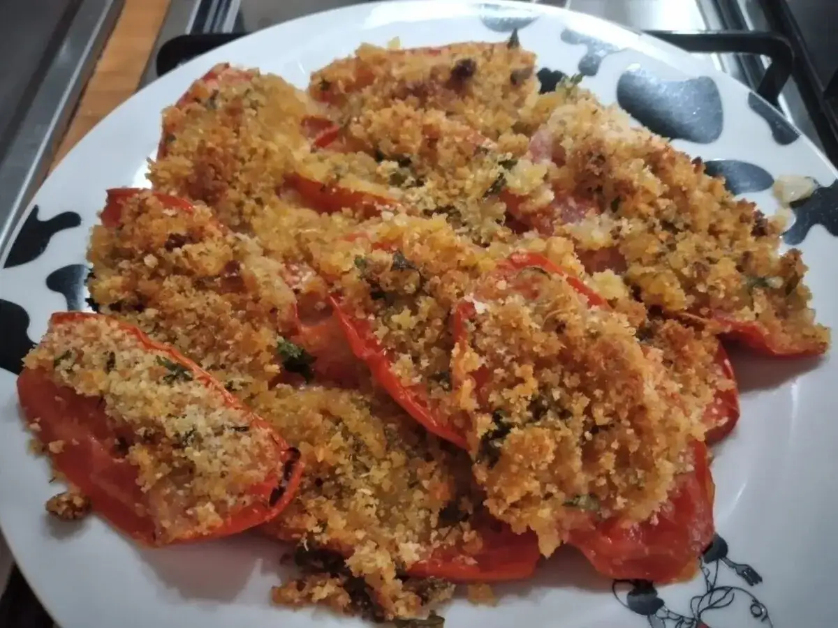 Pomodori gratinati al forno, un piatto semplice e gustoso, con una croccante panatura dorata.