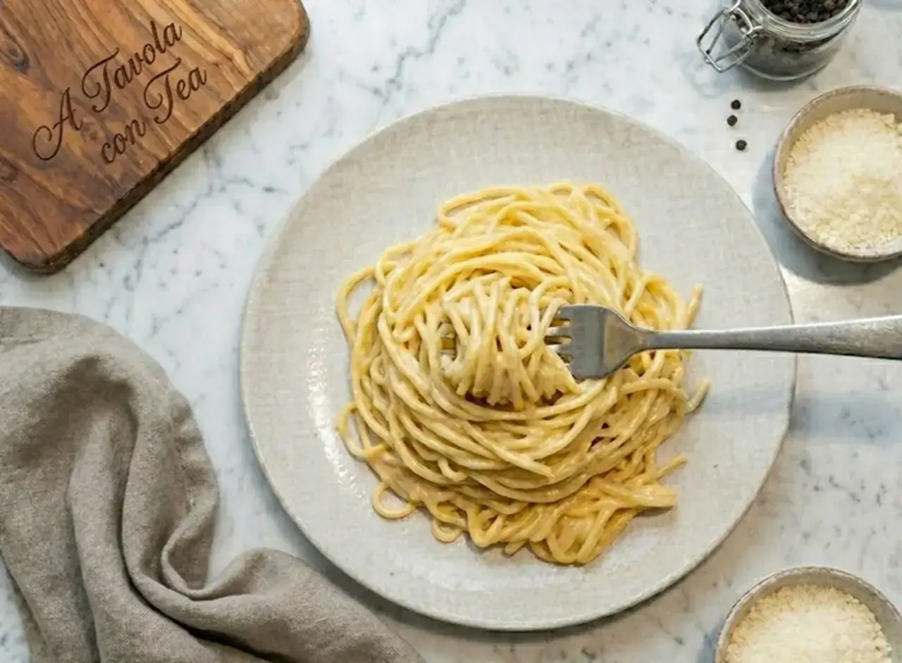 Spaghetti cremosi con una vellutata crema di parmigiano, pronti per essere gustati.