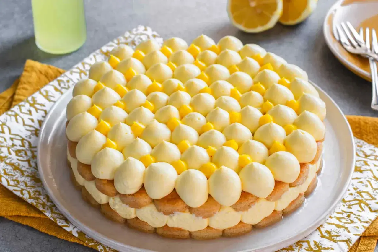 Delizioso tiramisù al limoncello, con strati di savoiardi, crema al limone e decorazioni di panna e limone.