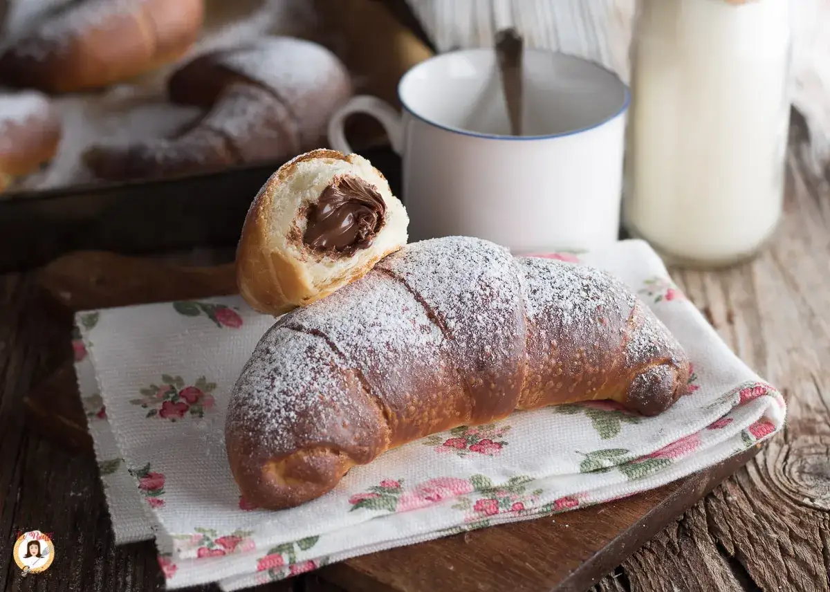 Cornetti fatti in casa veloci ripieni di crema al cioccolato, spolverati di zucchero a velo. Perfetti per la colazione!