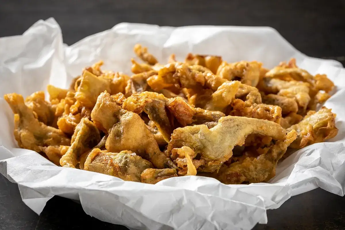 Carciiofi fritti alla romana, croccanti e dorati, preparati con una pastella leggera.