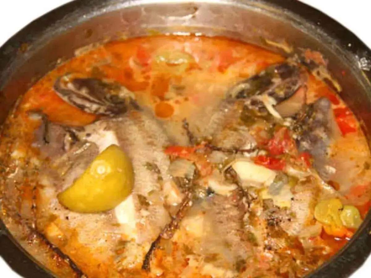 Un fumetto di pesce in umido, con pomodoro, limone e spezie, pronto per essere gustato.