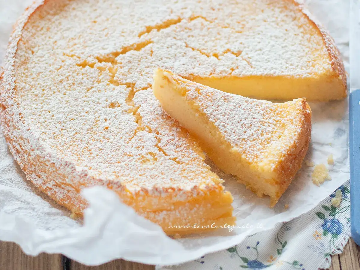 Una deliziosa torta ricotta veloce, spolverata di zucchero a velo, con una fetta tagliata.