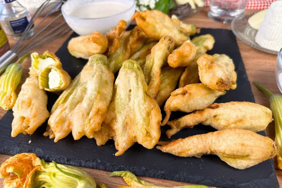 Fiori di zucca in friggitrice ad aria, dorati e croccanti, ripieni di formaggio. Un antipasto irresistibile pronto in poco tempo.