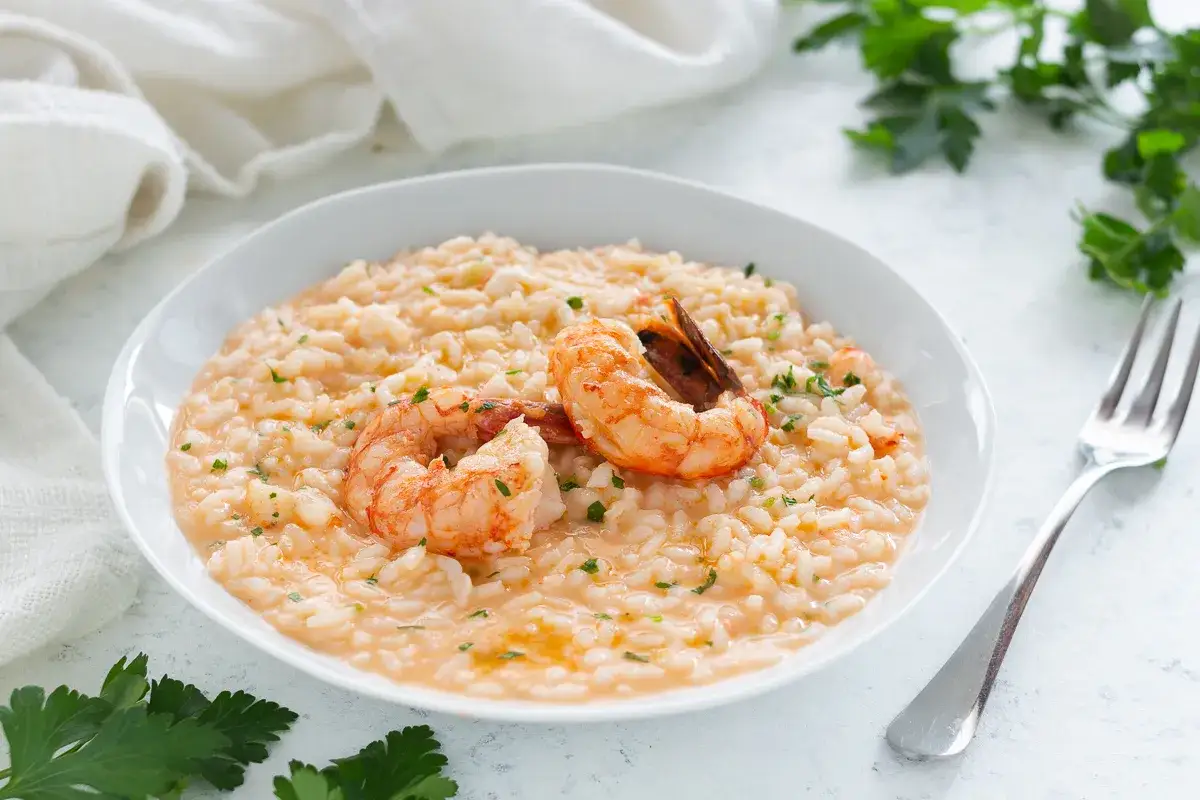 Risotto cremoso con gamberi, un piatto gustoso preparato con gamberi surgelati e prezzemolo tritato.