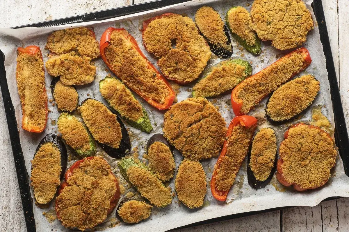 Verdure al forno saporite: peperoni, zucchine e melanzane gratinate con pangrattato dorato, pronte per essere gustate.