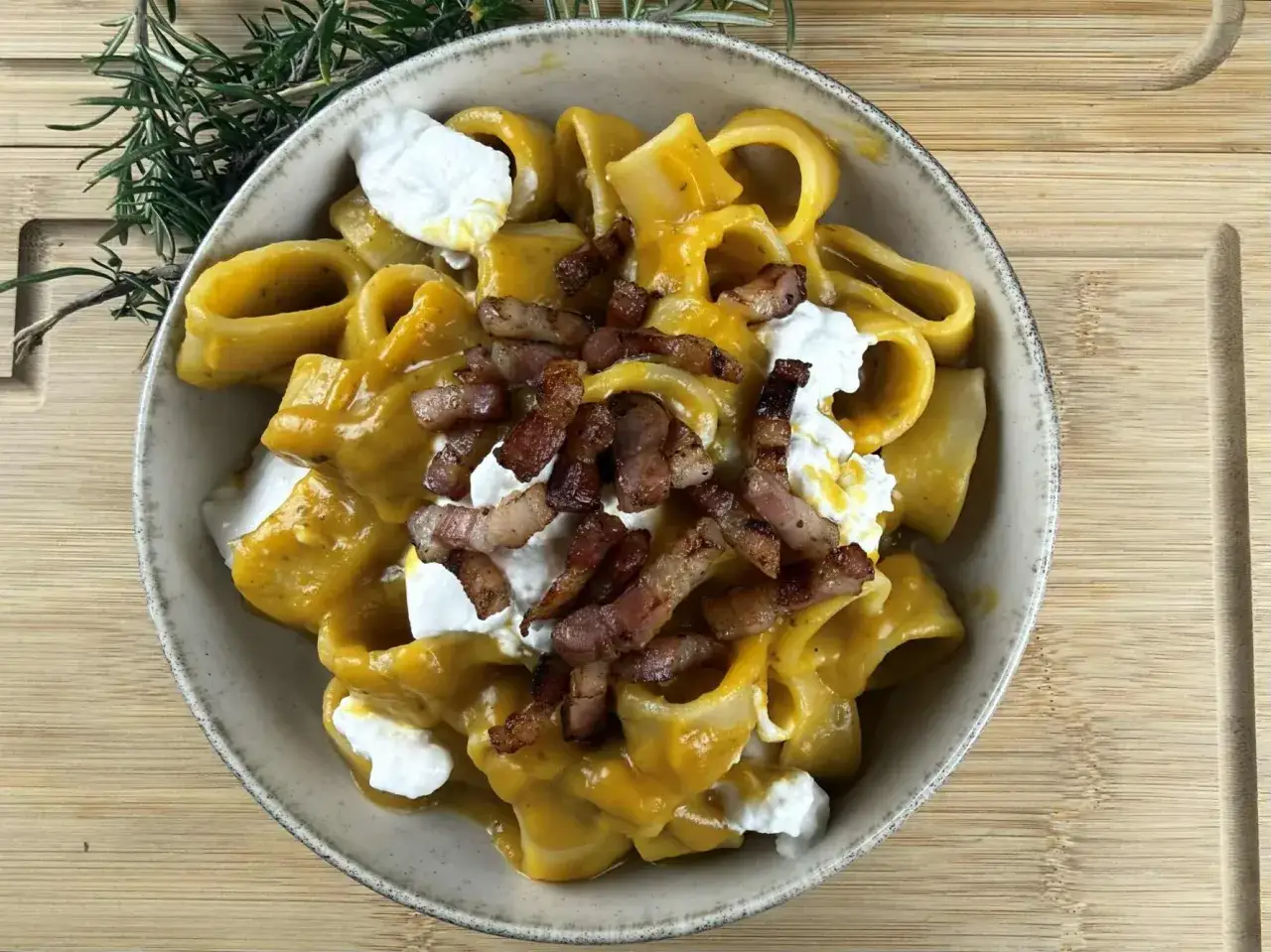 Piatto di pasta zucca e pancetta, con cubetti croccanti e ricotta fresca. Un connubio di sapori autunnali.