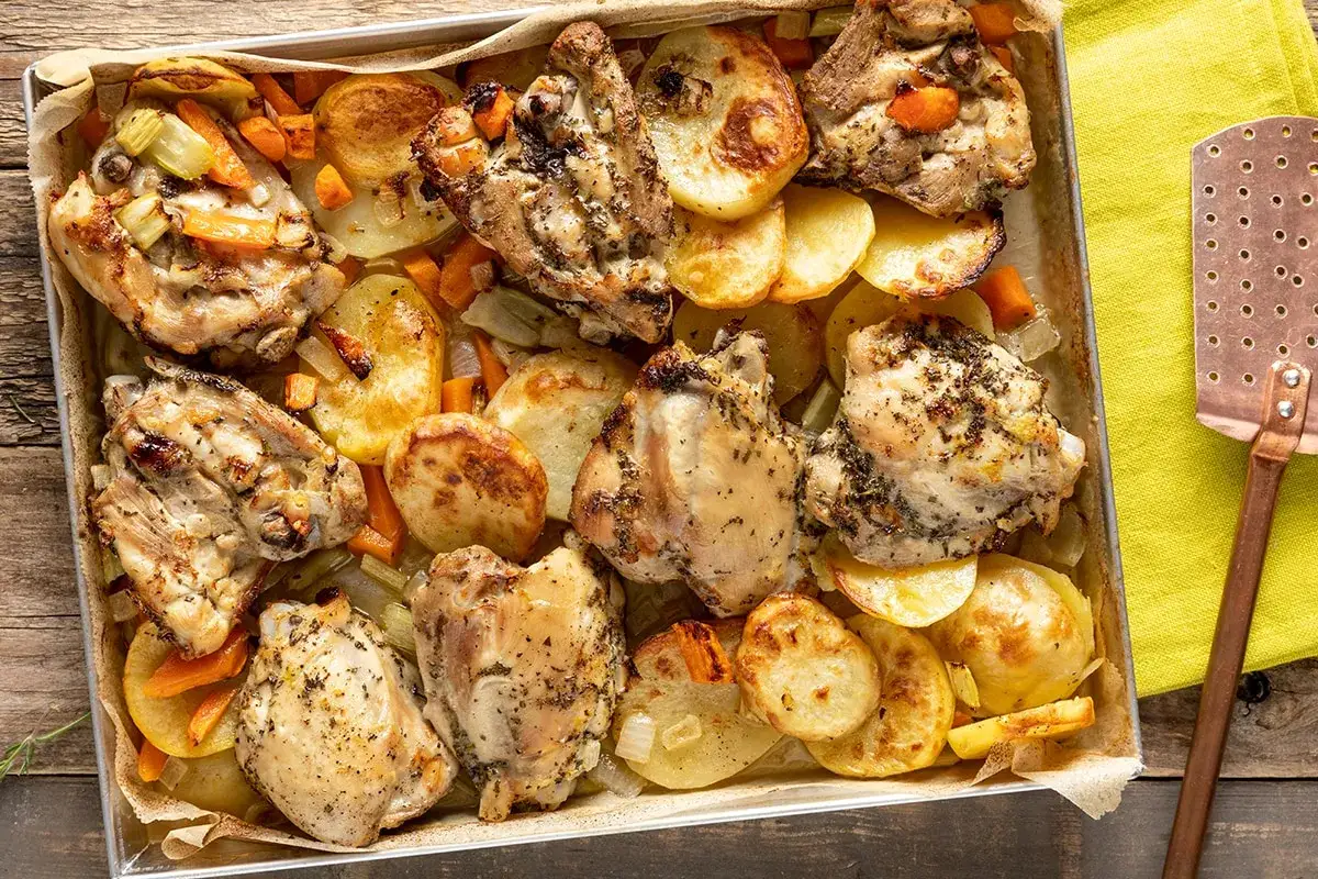 Sovracosce di pollo dorate e succulente, cotte al forno con patate, carote e sedano. Un piatto saporito e invitante.