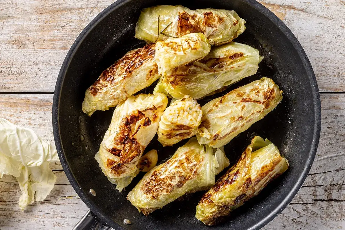 Involtini di verza dorati e saporiti cotti in padella, pronti per essere gustati.