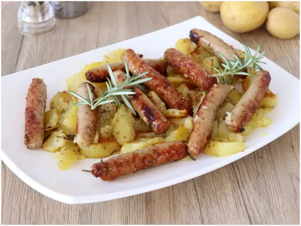 Salsicce e patate al forno, un piatto gustoso e profumato, con rosmarino fresco.