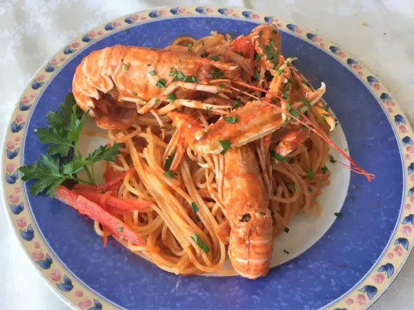 Linguine alla busara con scampi succulenti, un piatto di mare che profuma di festa e sapori autentici.