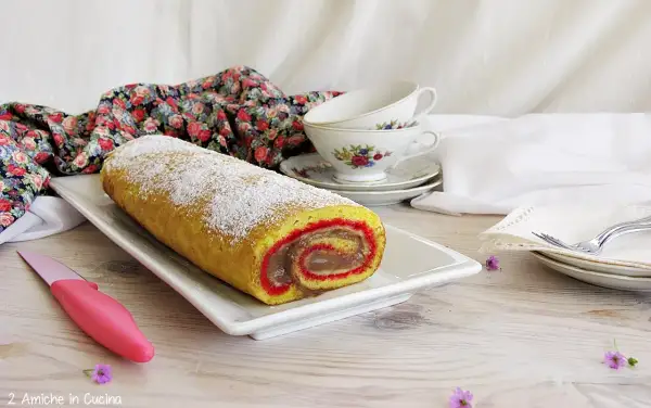 Rotolo dolce spolverato di zucchero a velo, un vero salame del re, con ripieno cremoso e bordi rossi.
