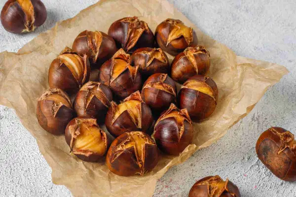 Castagne perfette cotte in friggitrice ad aria, con la buccia aperta che rivela il loro interno dorato e invitante.