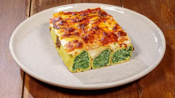 Crespelle alla fiorentina, rotoli di pasta ripieni di spinaci e ricotta, gratinati al forno con formaggio fuso.