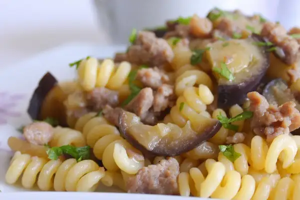 Fusilli con salsiccia e melanzane, un piatto gustoso e colorato, pronto per essere assaporato.