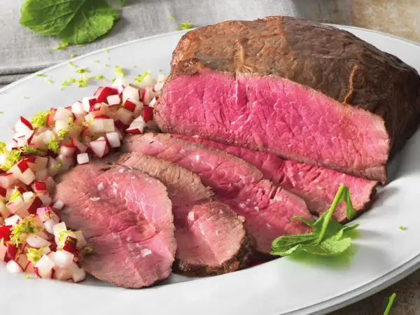 Succulento roast beef al forno, affettato e servito con un contorno di ravanelli e scorza di lime.