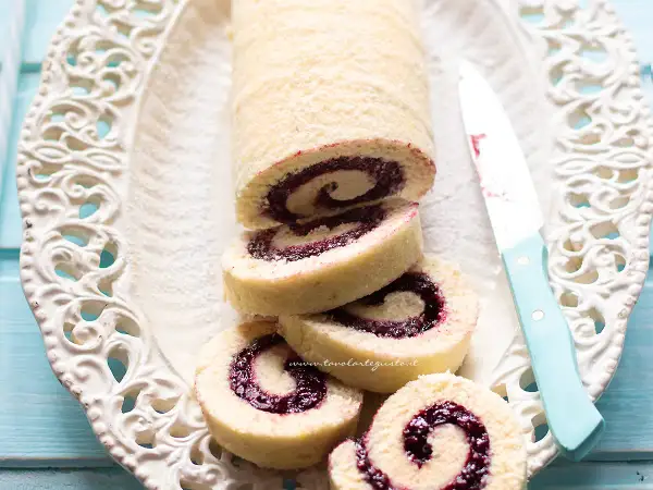 Un invitante rotolo alla marmellata, con la sua soffice pasta e il ripieno colorato, pronto per essere gustato.
